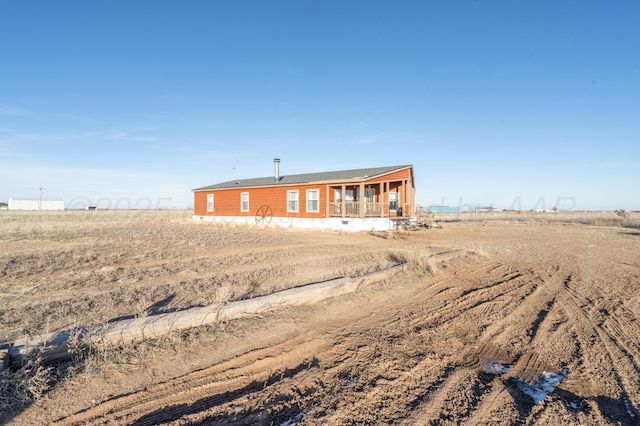 view of front facade featuring a porch and a rural view