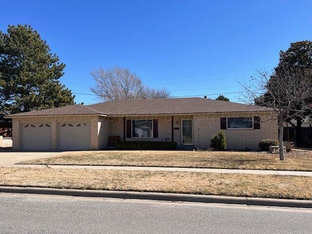 single story home featuring driveway, brick siding, and an attached garage