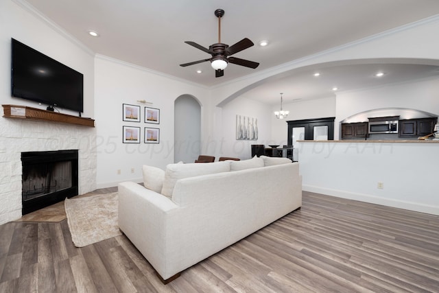 8603 Garden Way Dr, Amarillo, TX 79119 - living room with arched walkways, wood finished floors, a ceiling fan, a stone fireplace, and recessed lighting