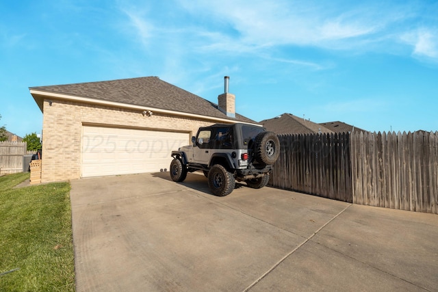 8603 Garden Way Dr, Amarillo, TX 79119 - view of home's exterior featuring driveway, brick siding, a garage, and a chimney
