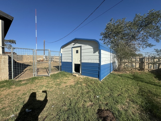 view of shed featuring fence and a gate