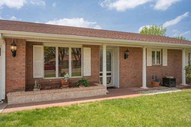 145 N Kingwood St, Hereford, TX 79045 - entrance to property with brick siding, a shingled roof, a lawn, and covered porch