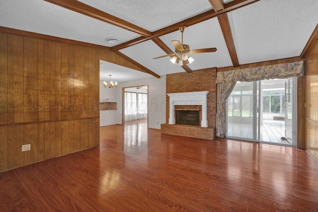 145 N Kingwood St, Hereford, TX 79045 - unfurnished living room with wood walls, a healthy amount of sunlight, ceiling fan with notable chandelier, and wood finished floors