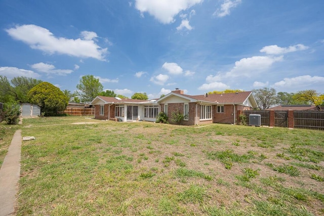 145 N Kingwood St, Hereford, TX 79045 - back of house featuring brick siding, a fenced backyard, a lawn, and a chimney