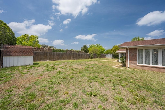 145 N Kingwood St, Hereford, TX 79045 - view of yard featuring a storage unit, fence, and an outbuilding
