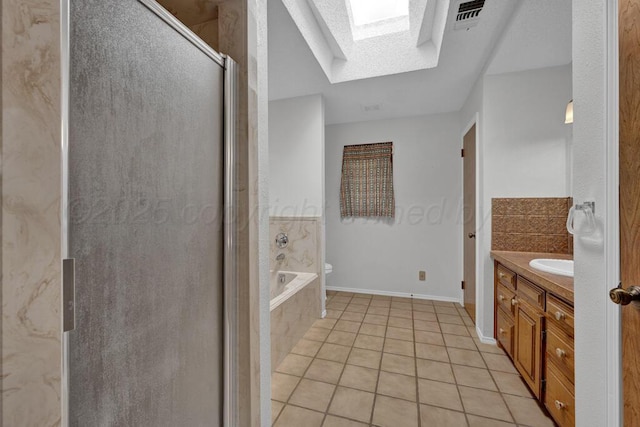 145 N Kingwood St, Hereford, TX 79045 - bathroom with a relaxing tiled tub, tile patterned flooring, vanity, a shower stall, and a skylight