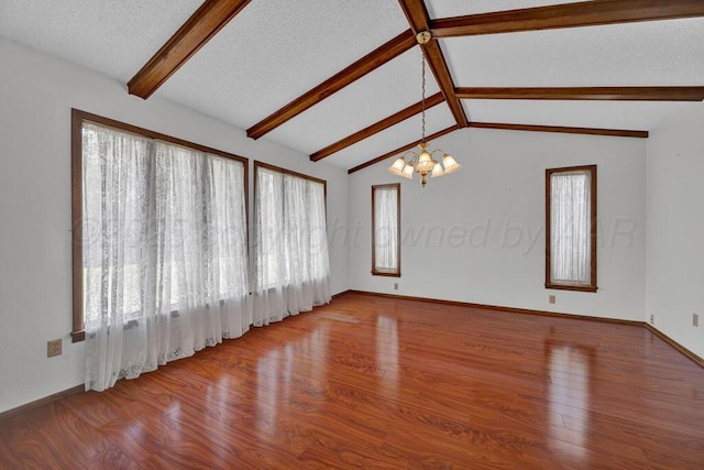 145 N Kingwood St, Hereford, TX 79045 - unfurnished living room with a wealth of natural light, lofted ceiling with beams, wood finished floors, and a notable chandelier
