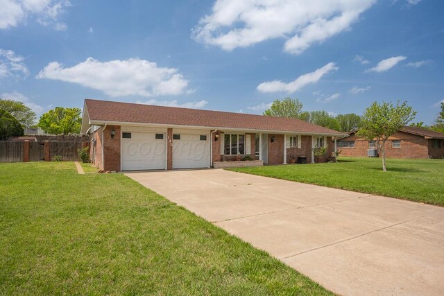 145 N Kingwood St, Hereford, TX 79045 - ranch-style house with fence, brick siding, a garage, a front yard, and driveway
