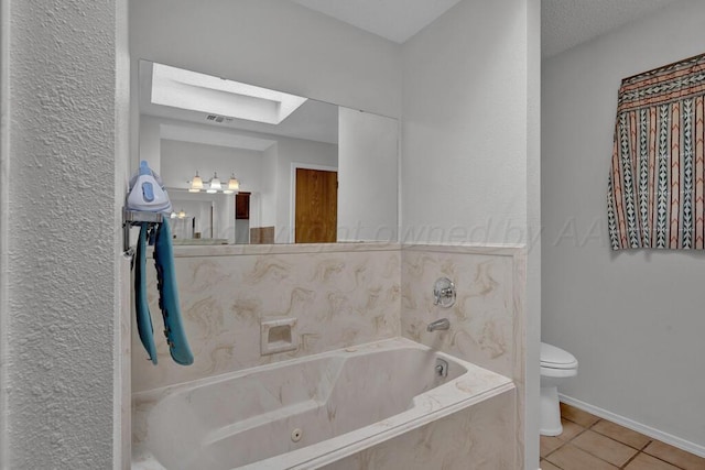 145 N Kingwood St, Hereford, TX 79045 - full bathroom with a garden tub, a skylight, tile patterned floors, baseboards, and toilet