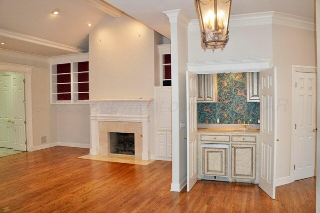 5105 Olsen Cir, Amarillo, TX 79106 - kitchen with wood finished floors, crown molding, a high end fireplace, a chandelier, and recessed lighting