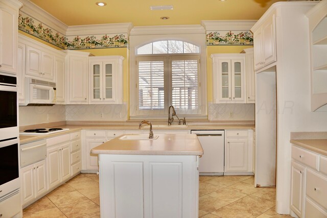 5105 Olsen Cir, Amarillo, TX 79106 - kitchen featuring white appliances, a kitchen island with sink, backsplash, light countertops, and a warming drawer
