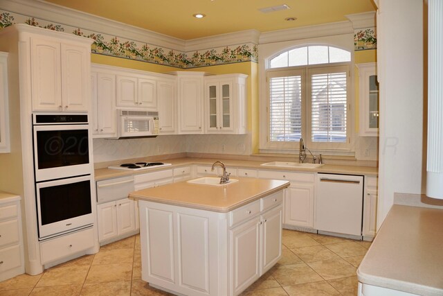 5105 Olsen Cir, Amarillo, TX 79106 - kitchen with white appliances, a warming drawer, a kitchen island with sink, light countertops, and ornamental molding