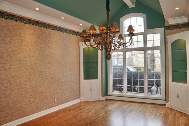 5105 Olsen Cir, Amarillo, TX 79106 - unfurnished dining area featuring a chandelier, wood finished floors, wallpapered walls, crown molding, and vaulted ceiling
