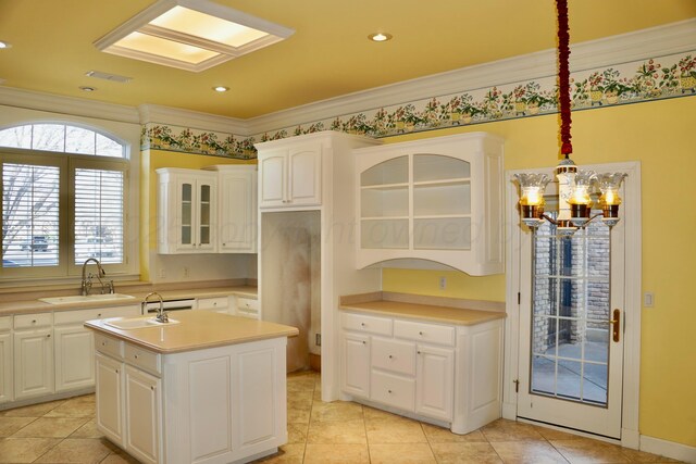 5105 Olsen Cir, Amarillo, TX 79106 - kitchen with a chandelier, glass insert cabinets, a kitchen island with sink, white cabinets, and light countertops