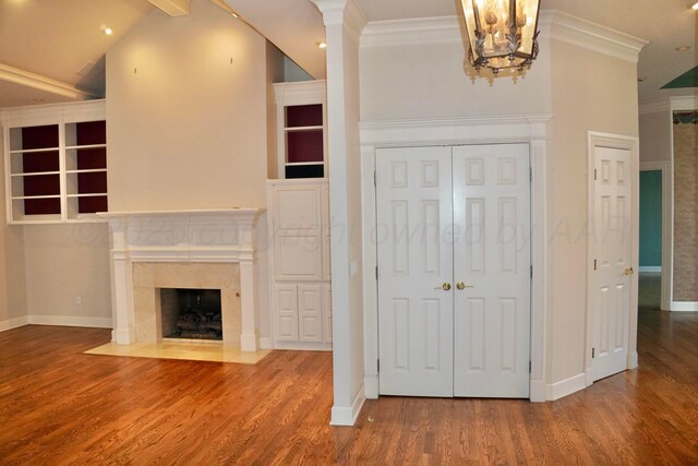 5105 Olsen Cir, Amarillo, TX 79106 - unfurnished living room featuring ornamental molding, wood finished floors, a high end fireplace, a chandelier, and vaulted ceiling