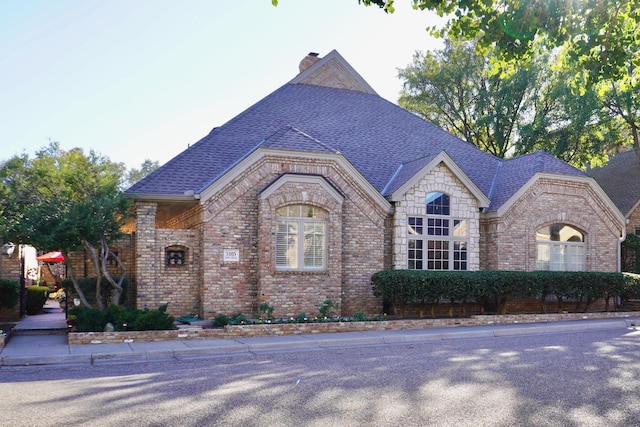 5105 Olsen Cir, Amarillo, TX 79106 - french country inspired facade featuring brick siding, a shingled roof, and a chimney