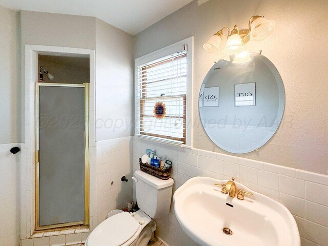 2209 N Beech Ln, Pampa, TX 79065 - full bathroom featuring tile walls, a sink, toilet, a shower stall, and wainscoting