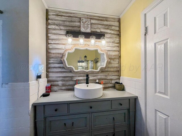 2209 N Beech Ln, Pampa, TX 79065 - bathroom featuring tile walls, vanity, wainscoting, and ornamental molding