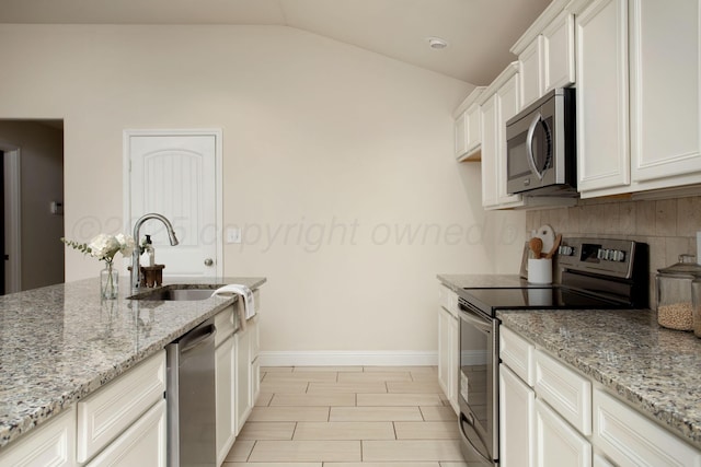 7308 Sinclair St, Amarillo, TX 79119 - kitchen with appliances with stainless steel finishes, lofted ceiling, light stone counters, white cabinetry, and tasteful backsplash