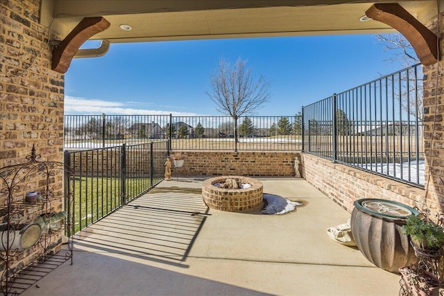 view of patio featuring fence and a fire pit