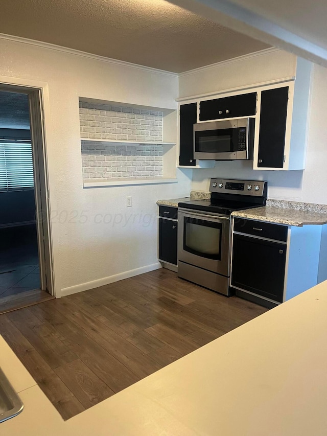 605 Star St, Hereford, TX 79045 - kitchen with stainless steel appliances, dark wood-style flooring, crown molding, dark cabinets, and light countertops