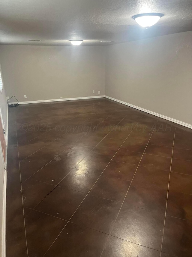 605 Star St, Hereford, TX 79045 - spare room with dark tile patterned flooring and a textured ceiling