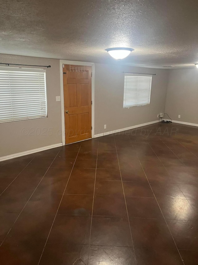 605 Star St, Hereford, TX 79045 - tiled spare room featuring a textured ceiling and baseboards