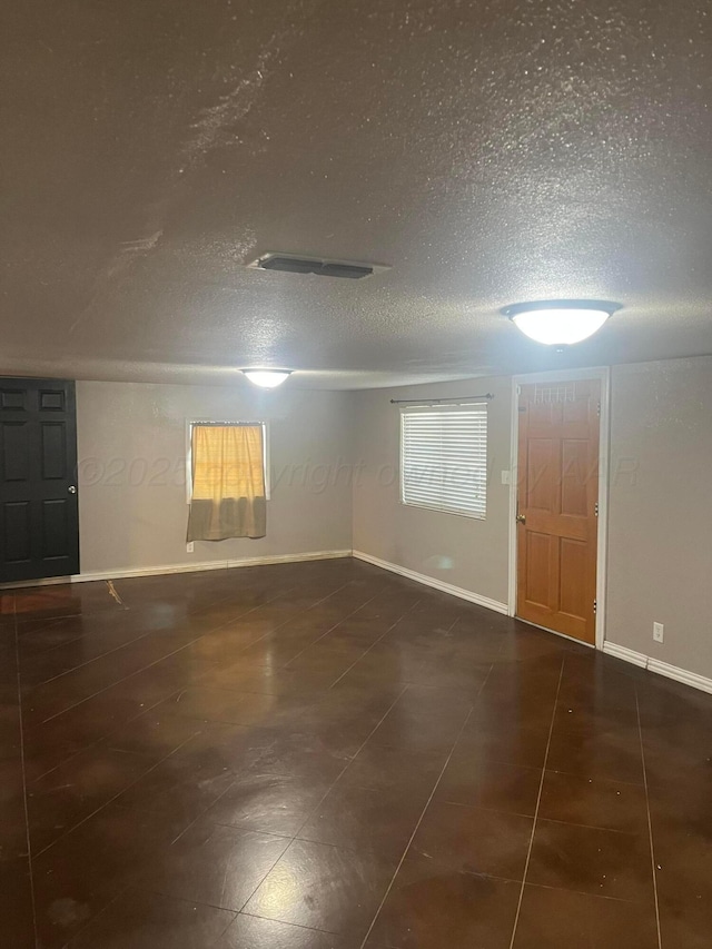 605 Star St, Hereford, TX 79045 - tiled empty room featuring a textured ceiling and baseboards