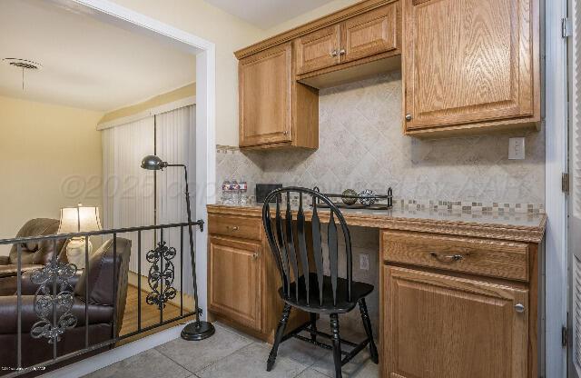 3406 Patterson Dr, Amarillo, TX 79109 - kitchen featuring backsplash, brown cabinets, and light tile patterned floors