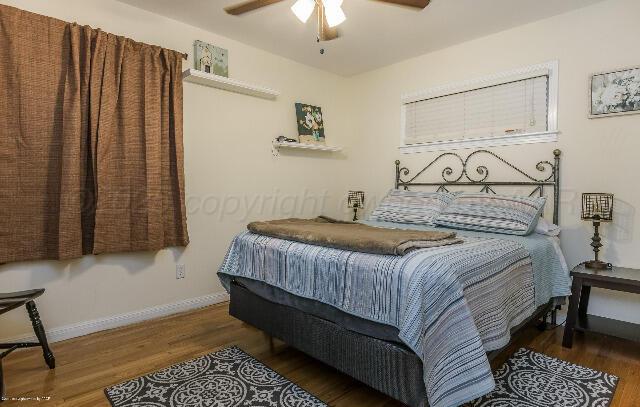 3406 Patterson Dr, Amarillo, TX 79109 - bedroom with wood finished floors, baseboards, and a ceiling fan