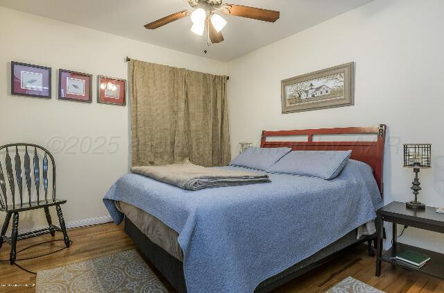 3406 Patterson Dr, Amarillo, TX 79109 - bedroom with wood finished floors, a ceiling fan, and baseboards