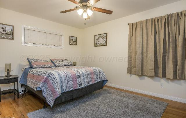 3406 Patterson Dr, Amarillo, TX 79109 - bedroom featuring baseboards, wood finished floors, and ceiling fan