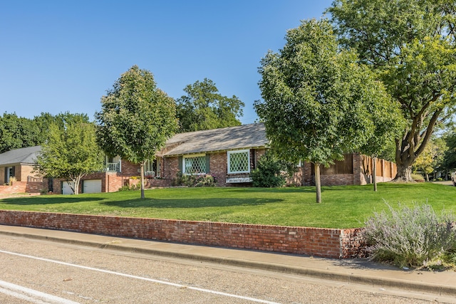 ranch-style home featuring a garage and a front yard