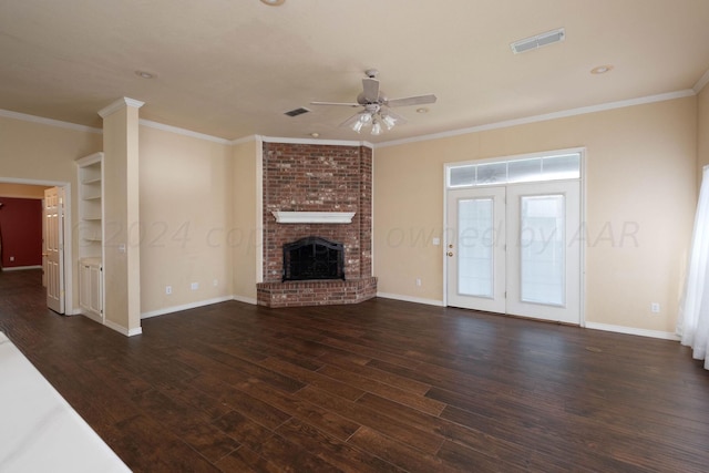 unfurnished living room with french doors, crown molding, a fireplace, dark hardwood / wood-style flooring, and ceiling fan