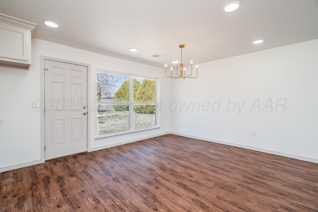 unfurnished dining area featuring a notable chandelier, baseboards, wood finished floors, and recessed lighting