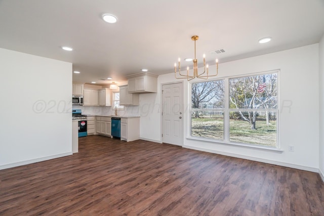 kitchen featuring dark wood-style flooring, a sink, light countertops, appliances with stainless steel finishes, and tasteful backsplash