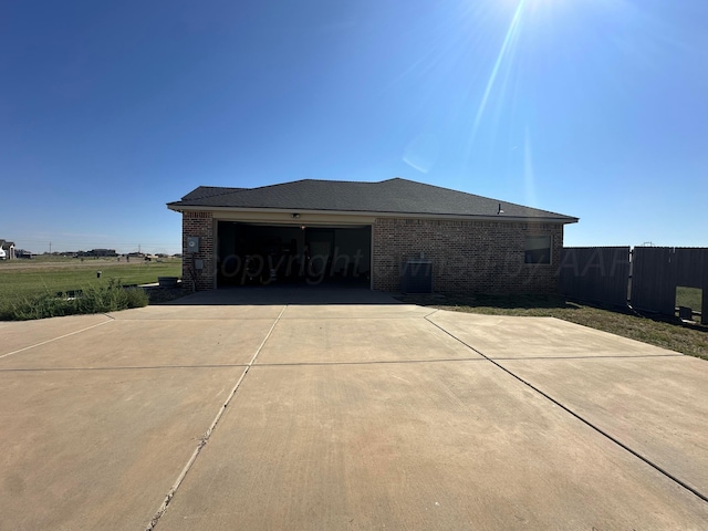 17901 19th St, Amarillo, TX 79124 - view of side of home with driveway, a garage, brick siding, cooling unit, and fence