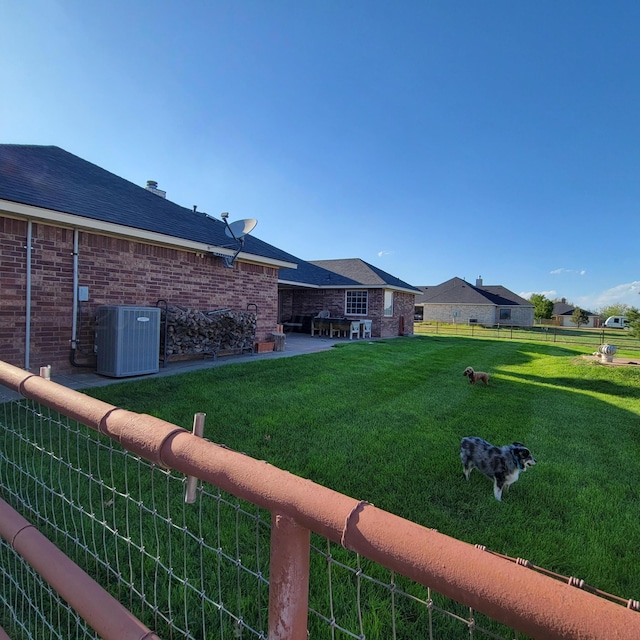 view of yard with fence and central AC unit