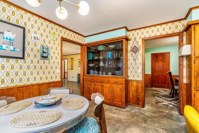 dining room featuring wooden walls, an inviting chandelier, and crown molding