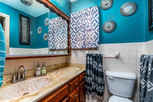 bathroom featuring vanity, toilet, and tile walls