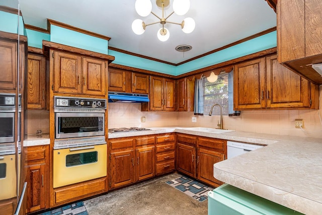 kitchen featuring tasteful backsplash, crown molding, appliances with stainless steel finishes, a notable chandelier, and sink