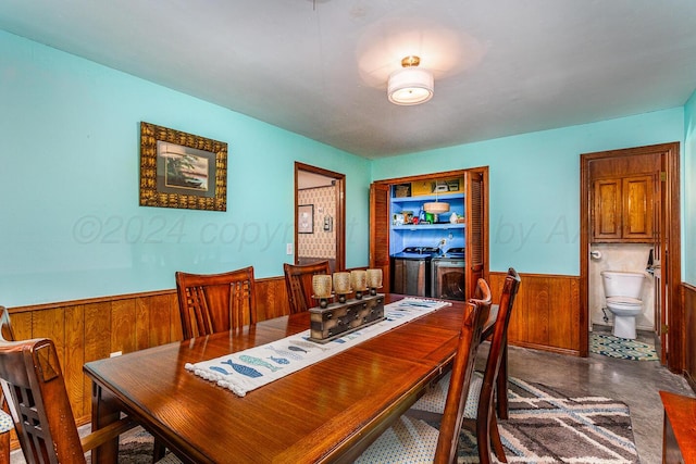 dining area with concrete flooring and wooden walls