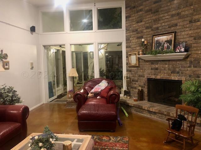 living room featuring a fireplace and a high ceiling