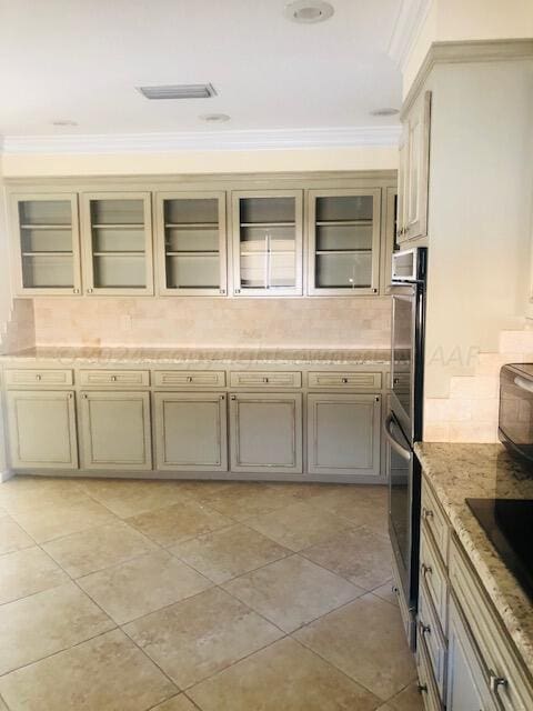 kitchen with black electric cooktop, stainless steel double oven, crown molding, and decorative backsplash