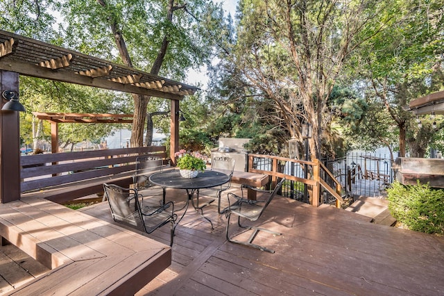 deck featuring outdoor dining space, a pergola, and fence