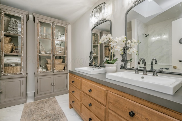 bathroom featuring a sink, a tile shower, and double vanity
