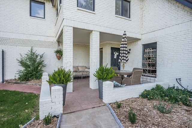 doorway to property with a patio area and brick siding