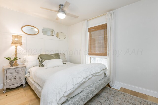 bedroom featuring wood finished floors, ceiling fan, and baseboards