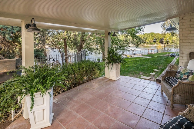view of patio / terrace with a water view and fence