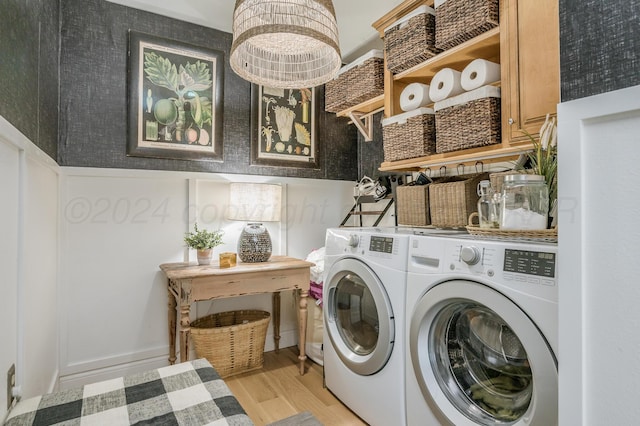 washroom featuring light wood-style floors, cabinet space, and washer and clothes dryer